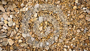 Natural crumb of goldstone or zlatolite for a stone background. Texture of orange, sand and brown pebbles. Stone chips for