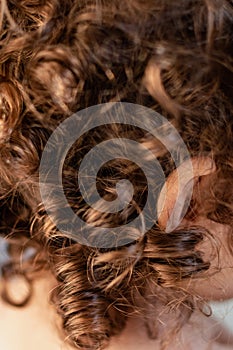 Natural curly hair, little girl with light brown curls and golden reflections