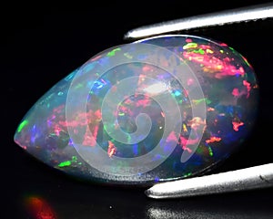 natural dark multicolor rainbow opal gem on the background