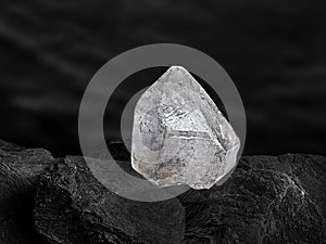 Natural diamond nestled on black coal background
