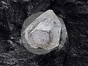 Natural diamond nestled on black coal background