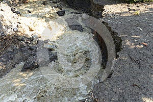 A natural disaster of flooding, muddy streams of water with stones and mud in the streets of the city