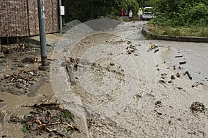 A natural disaster of flooding, muddy streams of water with stones and mud in the streets of the city