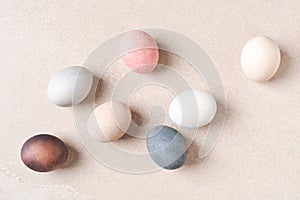 Natural dyed Easter eggs on beige table.