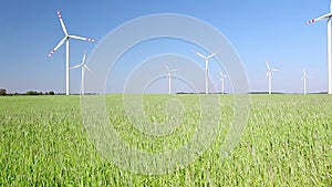 Natural energy - windmills and green grain field