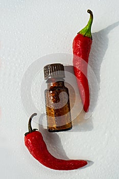 Natural essential oil with chili pepper additives. Essential oil of red pepper.