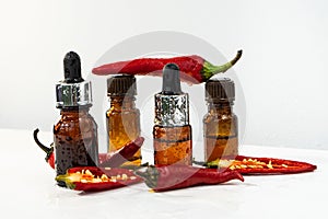 Natural essential oil with chili pepper additives. Essential oil of red pepper.