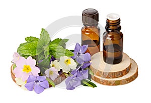 Natural essential oil in glass bottles and medicinal herbs bouquet isolated on white background