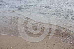 Natural filled frame close up background wallpaper shot of an ocean wave on the smooth yellow sand beach surface. Pitiwella beach