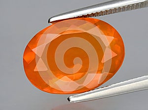 natural fire orange opal gem on the background