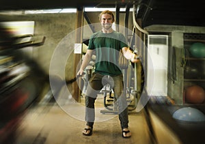 Natural fitness lifestyle portrait of young happy and attractive man training at gym smiling cheerful doing battle ropes workout