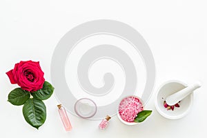 Natural floral cosmetics with rose flowers for face and body care on white background top view mock up