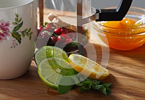 Natural flu treatment: still life with lime, lemon, mint leaf, orange jam, and berry tea