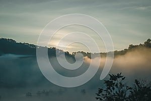 Natural fog and mountains sunlight background blurring, misty waves warm colors and bright sun light. Background sky sunny color