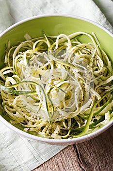 Natural food: raw zucchini pasta in a bowl closeup. Vertical