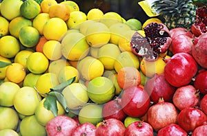 Natural fresh fruits yellow lemons, oranges and red pomegranates
