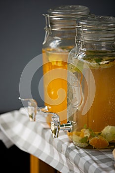 Natural fruit content refreshment cold drinks in glass containers outdoor, on tabletop.