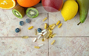 Natural fruits and multivitamin capsules. Natural and synthetic sources of vitamins