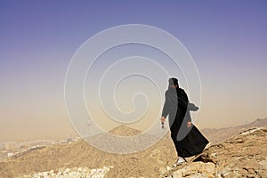Natural full body young muslim woman portrait in Ghar Thowr, Mecca, Saudi Arabia, in a sunny and clear sky day photo