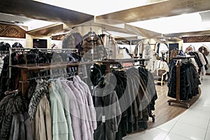 Natural fur coats hang on hangers in a store. Sale of winter warm clothes. Turkish shop