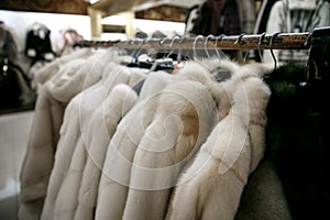 Natural fur coats hang on hangers in a store. Sale of winter warm clothes. Turkish shop