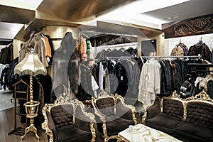 Natural fur coats hang on hangers in a store. Sale of winter warm clothes. Turkish shop