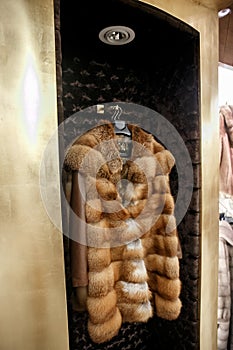Natural fur coats hang on hangers in a store. Sale of winter warm clothes. Turkish shop