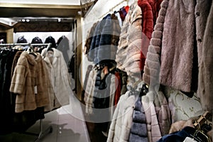 Natural fur coats hang on hangers in a store. Sale of winter warm clothes. Turkish shop