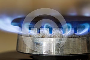 Natural gas blue flames burns on the kitchen stove hob, close up
