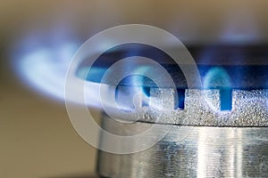 Natural gas blue flames burns on the kitchen stove hob, close up