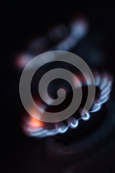 Natural gas burning a blue flames on black background