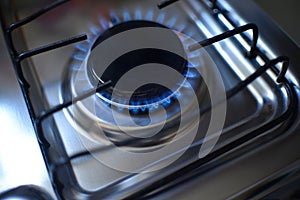 Natural gas burning by blue flames in kitchen stove. Food cooking concept.