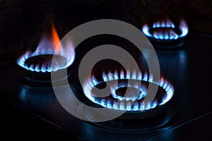 Natural gas burning on the stove. Blue flame. Three burners.