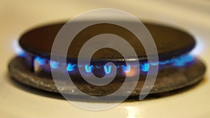 Natural gas burning on white enameled domestic stove at kitchen. Close up of natural gas flames in stove on the domestic