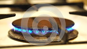 Natural gas burning on white enameled domestic stove at kitchen. Close up of natural gas flames in stove on the domestic