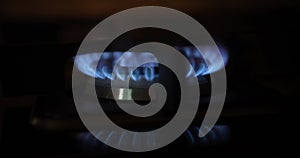 Natural gas burns with blue flame on black background