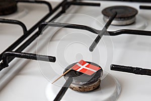 Natural gas exports and imports. High price. Danish flag on gas stove