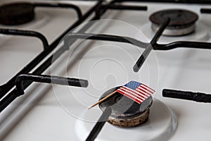 Natural gas exports and imports. High price. Flag of the United States of America on gas stove