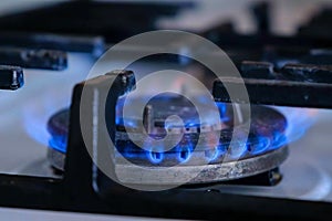Natural gas flame burns brighter and fades in stove burner. Gas burning.