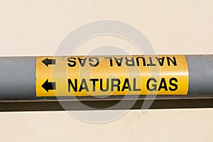 Natural gas marker on pipe with an arrow to indicate flow