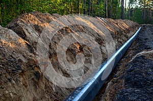 Natural gas pipeline construction work. A dug trench in the ground for the installation and installation of industrial gas and oil