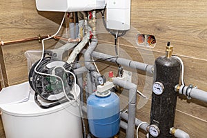 Natural gas valves and pipes in a modern home boiler room with ceramic tiles.