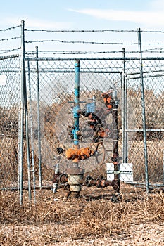 A natural gas well head fenced in for security