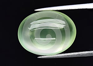 Natural gemstone green prehnite on gray background