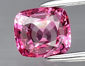 Natural gemstone pink spinel on gray background