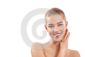 Natural glow. Portrait of a beautiful and positive blond woman with short hair and nude make up touching her face with