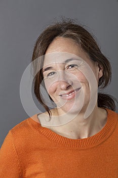 Natural, gorgeous middle aged woman smiling for serenity and wellness