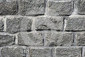 Natural granite stone wall. Rough natural stones. Background of a stone wall cladding texture gray stone bricks
