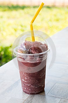 Natural grape smoothie and straw in plastic cup