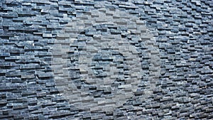 Natural gray brick used as a wall. The bricks are arranged alternately horizontally